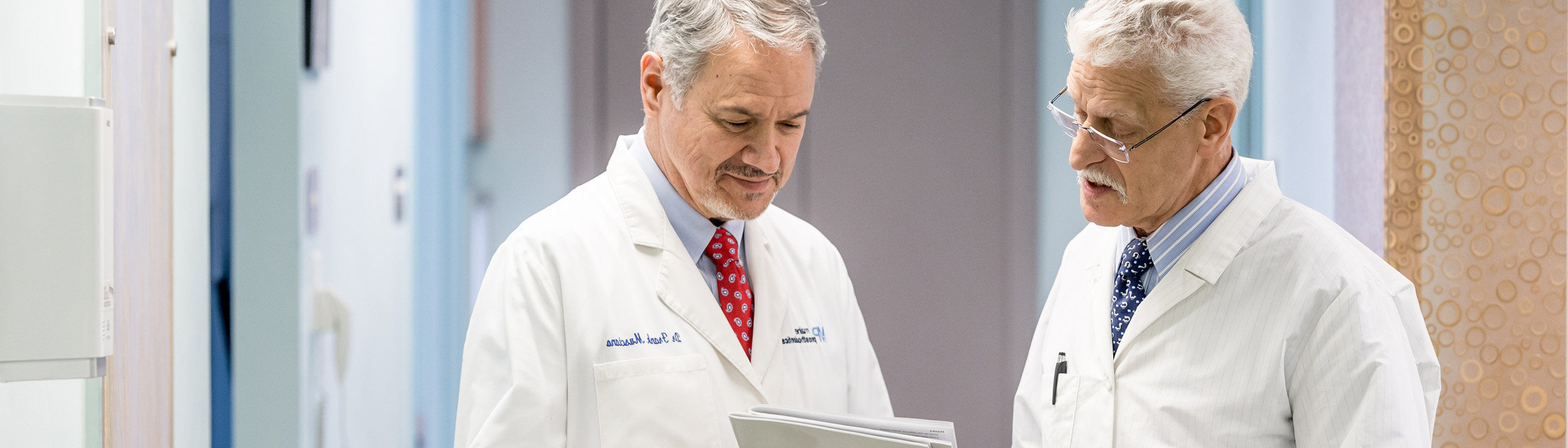 Two doctors in lab coats looking at a chart.