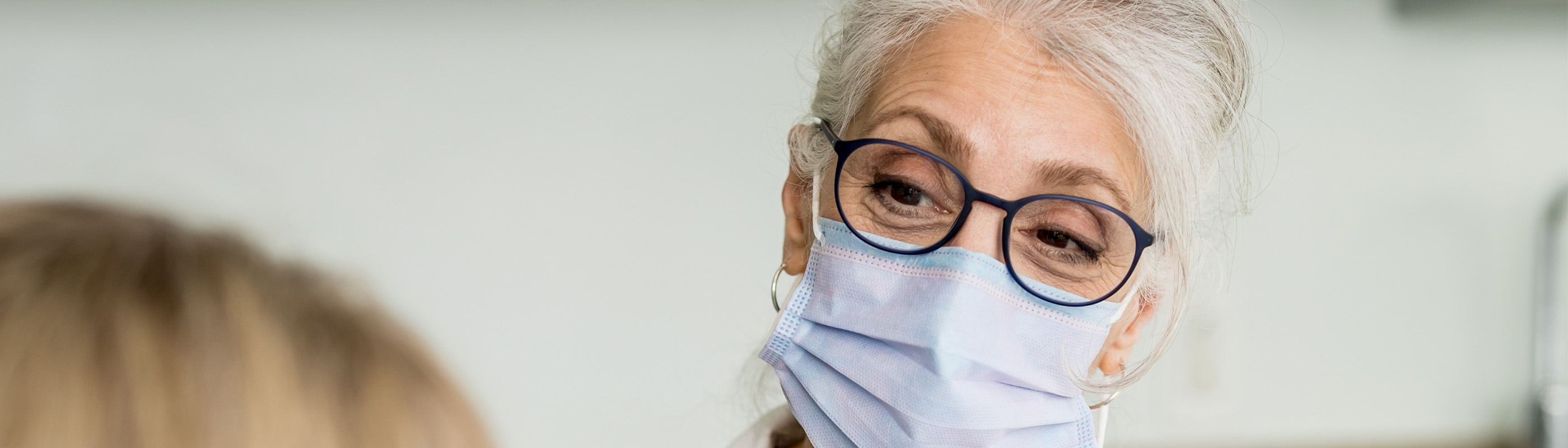 Masked doctor talking with a patient.